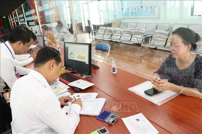 Cán bộ giải quyết thủ tục hành chính cho người dân. Cán bộ giải quyết thủ tục hành chính cho người dân.