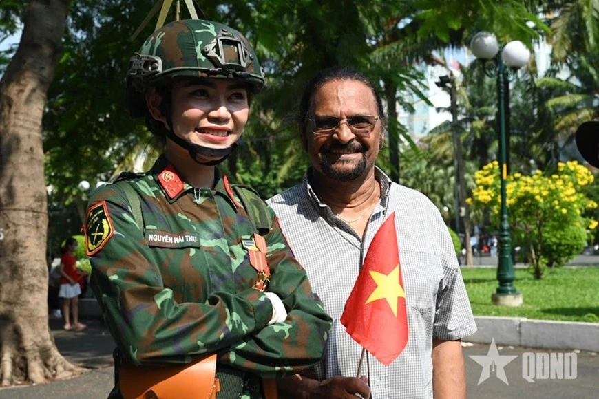 Du khách quốc tế chụp ảnh với nữ quân nhân Việt Nam trong ngày hội hòa bình, thống nhất non sông.