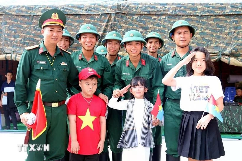 Các em thiếu nhi chụp ảnh lưu niệm với các chiến sỹ Đội pháo lễ, Lữ đoàn 96, Binh chủng pháo binh sau giờ luyện tập bắn đại bác tại công viên Bến Bạch Đằng, Quận 1, Thành phố Hồ Chí Minh.