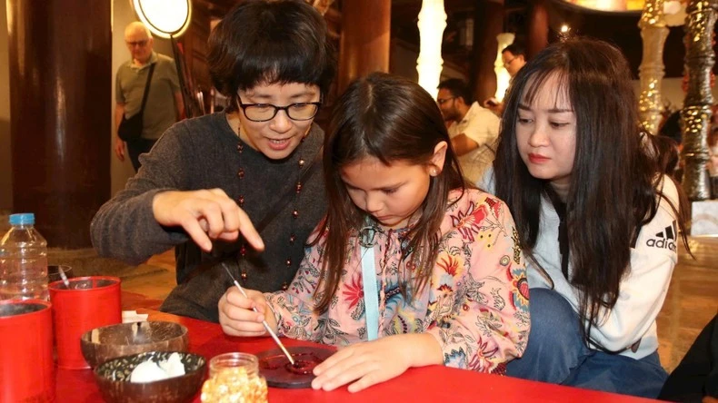 Các nghệ sĩ cùng khách tham quan làm tác phẩm sơn mài tại Văn Miếu - Quốc Tử Giám.