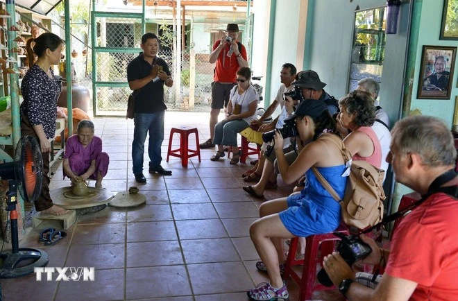 Khách du lịch thăm quan, xem và nghe giới thiệu về cách làm gốm truyền thống của người dân Thanh Hà.