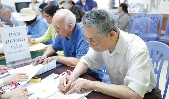 Cán bộ BHXH hướng dẫn người cao tuổi nhận lương hưu, trợ cấp BHXH qua các tài khoản cá nhân.