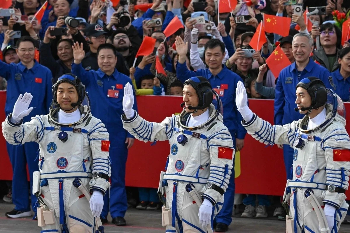 Các phi hành gia Trung Quốc (từ trái sang) Lý Quang Tô, Lý Công và Diệp Quang Phúc vẫy tay chào trước chuyến hành trình đến trạm vũ trụ Thiên Cung trên tàu Thần Châu-18 vào tháng 4.