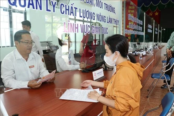 Người dân đến làm thủ tục hành chính trong ngày đầu vận hành thử tại phường Chánh Hiệp (phường mới) - đơn vị mới được thành lập trên cơ sở sáp nhập phường Tương Bình Hiệp, Định Hòa và một phần phường Chánh Mỹ, Hiệp An (thành phố Thủ Dầu Một - Bình Dương).