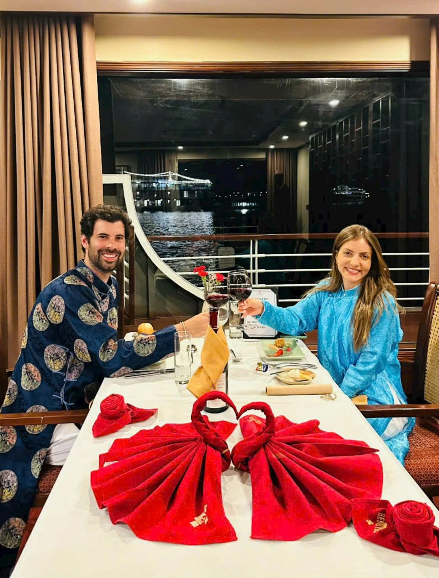 Cặp đôi khách nước ngoài trong trang phục áo dài Việt Nam chuẩn bị dùng bữa tối.