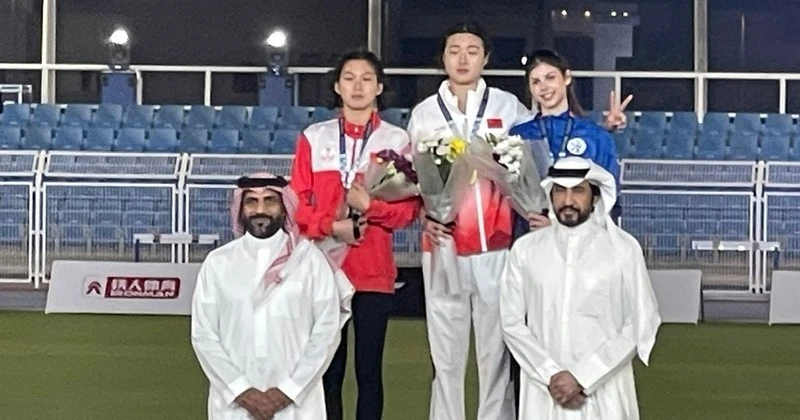 Mai Ngọc Ánh (bên trái, áo đỏ) trên bục nhận Huy chương.