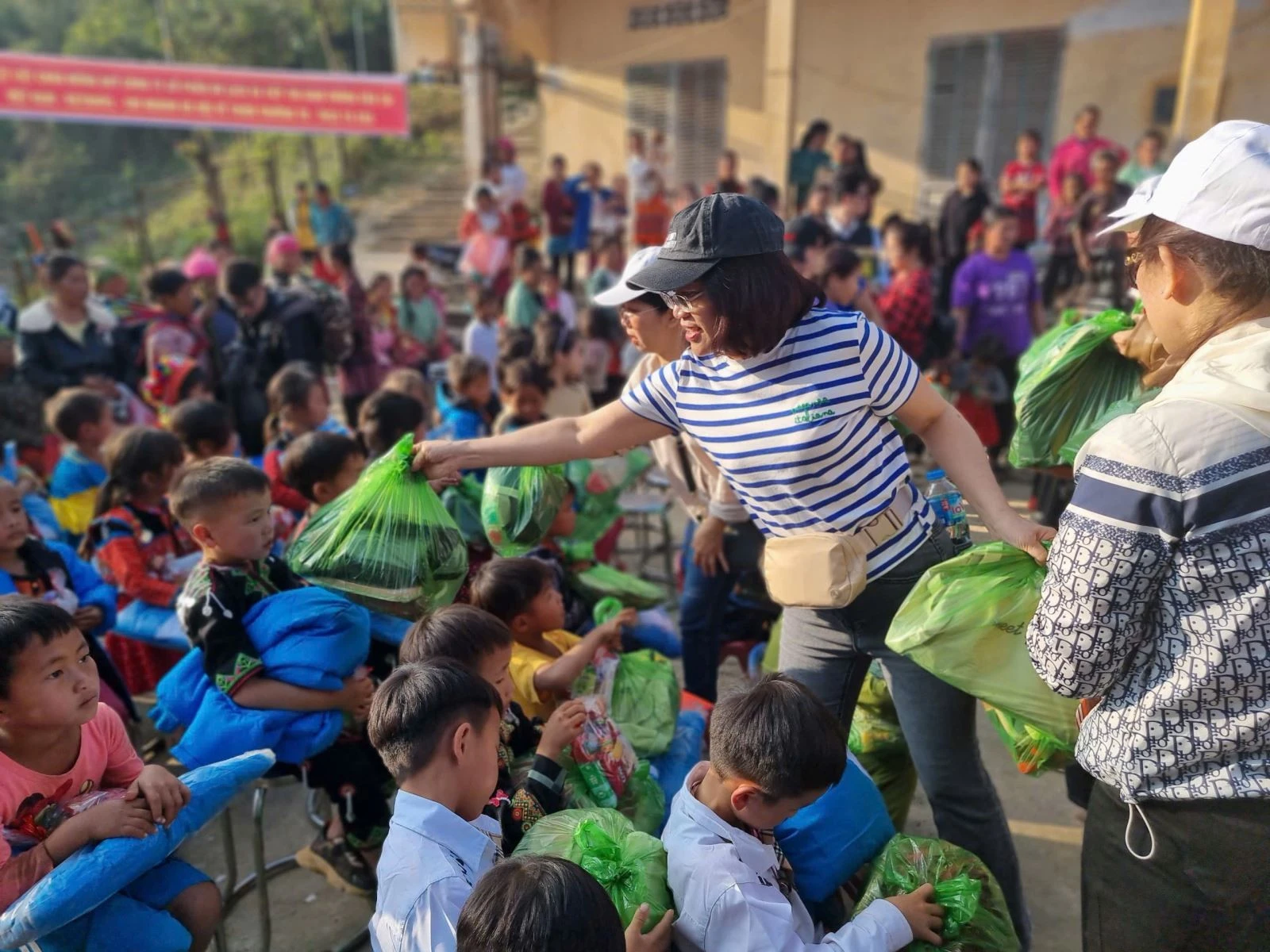 Du khách tự tay trao phần quà, sách vở học tập cho các em học sinh.