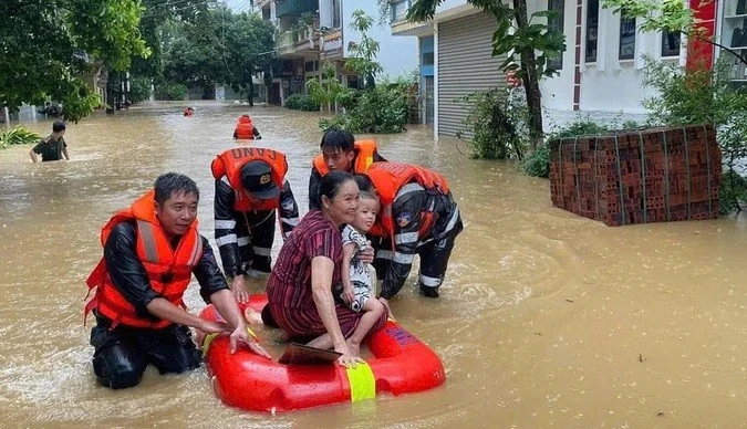 Lực lượng chức năng đưa người dân tại TP Lào Cai ra khỏi vùng ngập.