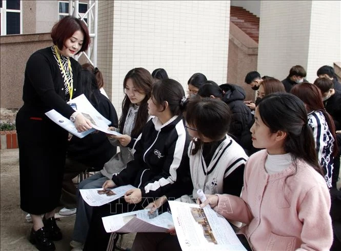 Cán bộ Trung tâm Dịch vụ việc làm tỉnh Bắc Giang phát tờ rơi về nhu cầu tuyển dụng của doanh nghiệp cho người lao động.