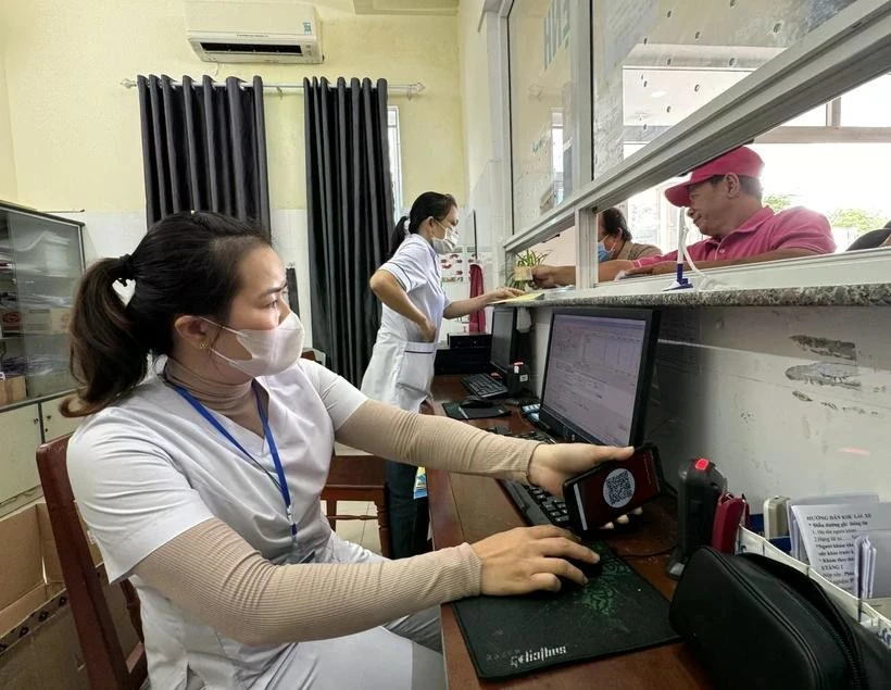 Nhân viên y tế quét mã lấy số và đăng ký khám bệnh tại các ki-ốt phát số tự động.