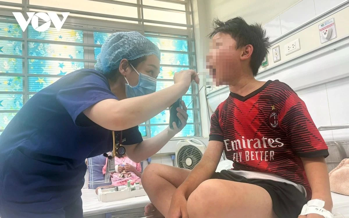 Bác sĩ đang thăm khám cho bệnh nhi Trần Phú Hào (10 tuổi, huyện Nghĩa Hưng, tỉnh Nam Định).