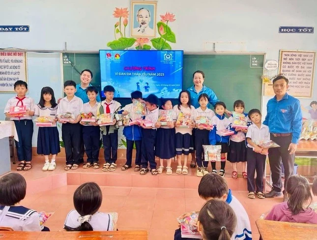 Ban tổ chức tặng quà cho học sinh tiểu học.