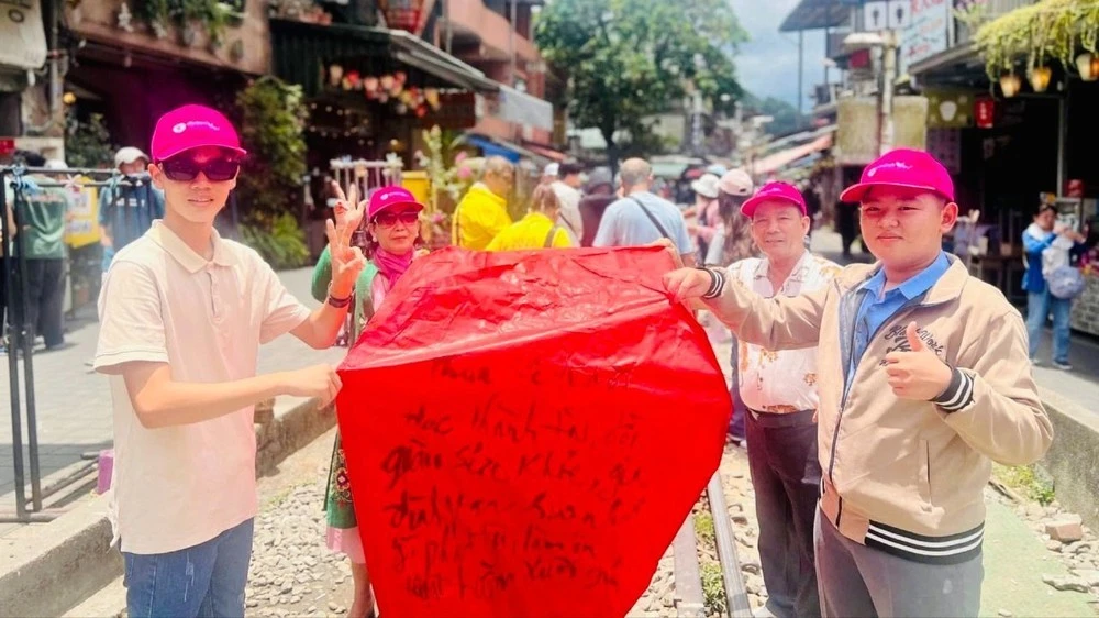 Du khách Việt viết chữ cầu may mắn trước khi thả lồng đèn tại Phố cổ Thập Phần ở lãnh thổ Đài Loan.