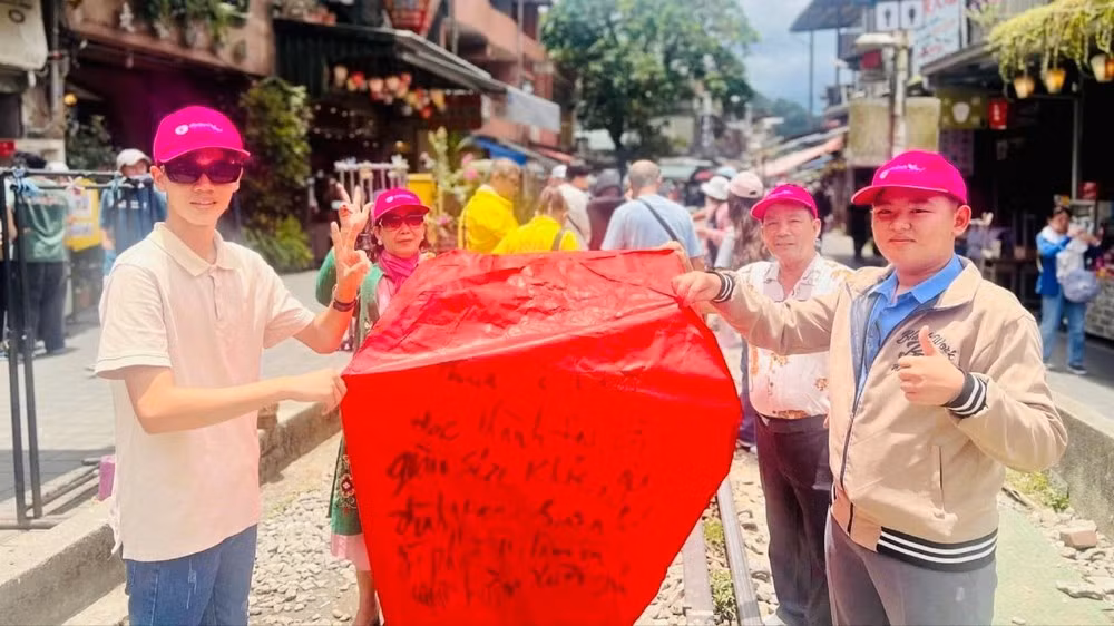 Du khách Việt viết chữ cầu may mắn trước khi thả lồng đèn tại Phố cổ Thập Phần ở lãnh thổ Đài Loan.
