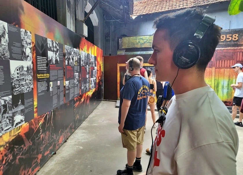 Du khách quốc tế nghe giới thiệu về di tích lịch sử nhà tù Hoả Lò, khi ghé thăm Thủ đô Hà Nội.