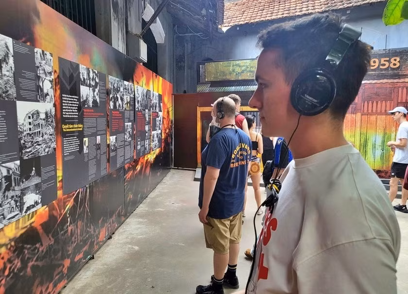 Du khách quốc tế nghe giới thiệu về di tích lịch sử nhà tù Hoả Lò, khi ghé thăm Thủ đô Hà Nội.