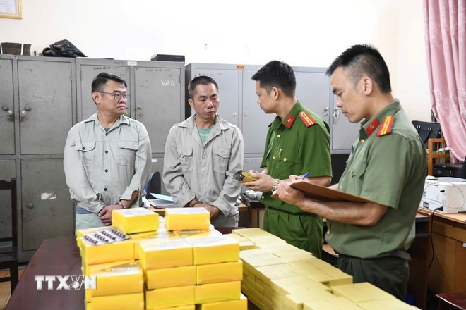 Lực lượng chức năng bắt giữ các đối tượng (trái) và tang vật vụ án. Lực lượng chức năng bắt giữ các đối tượng (trái) và tang vật vụ án.