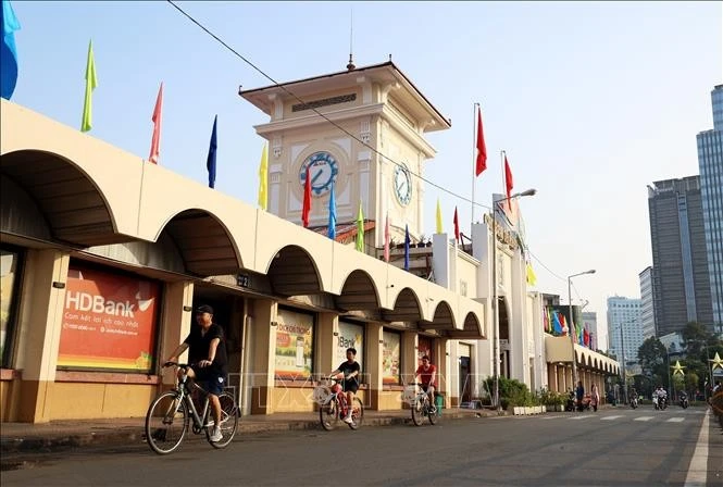 Khách du lịch đạp xe trải nghiệm không gian đô thị trung tâm TP Hồ Chí Minh buổi sáng sớm.