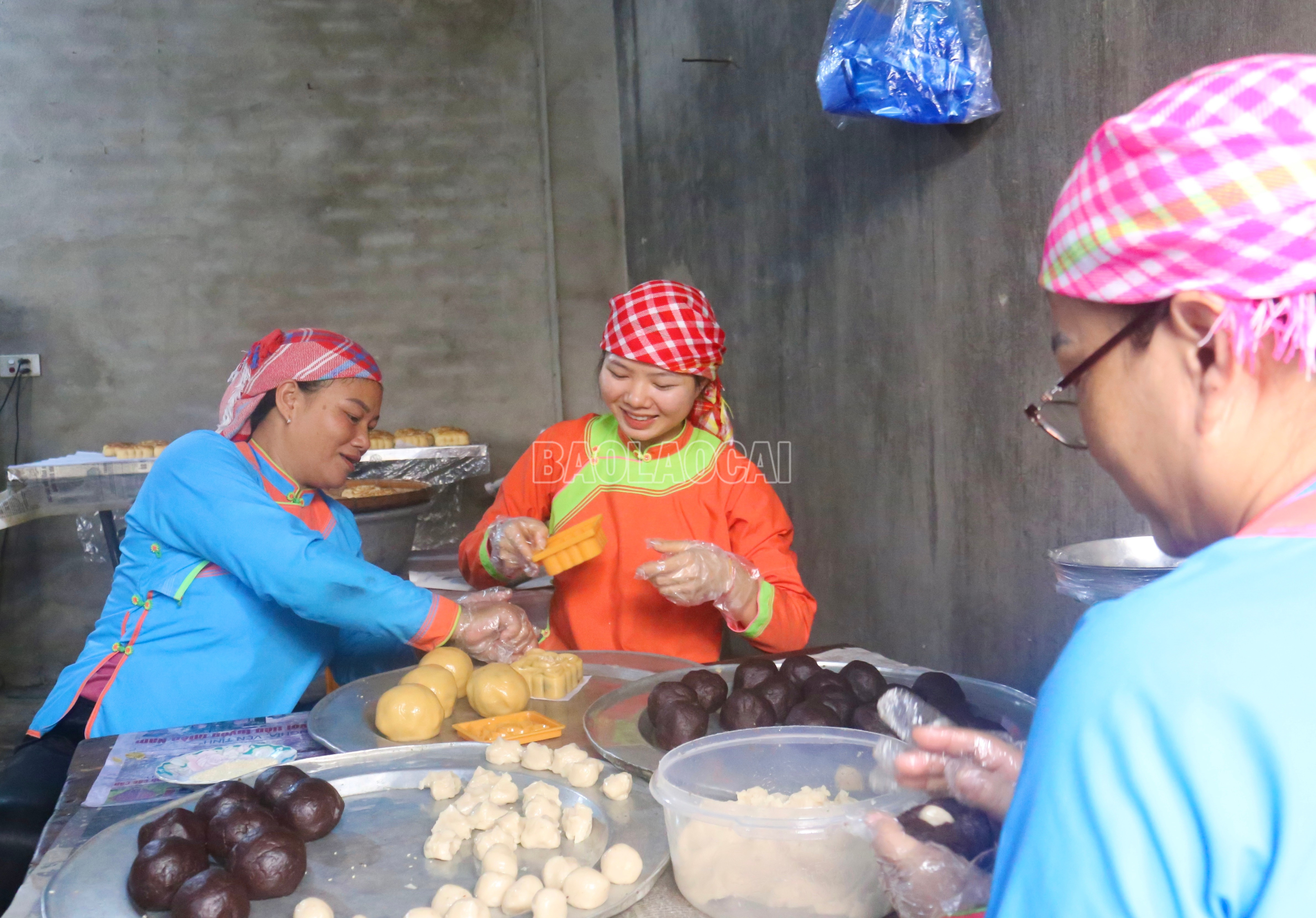 Theo chị Hồ Thị Bích (áo xanh bên trái), nghề làm bánh Trung thu của người Giáy ở Tân Hồng đã có từ lâu đời. Qua thời gian, nghề truyền thống này vẫn được gìn giữ, lan toả qua nhiều thế hệ. baolaocai-c_img-6537.jpg