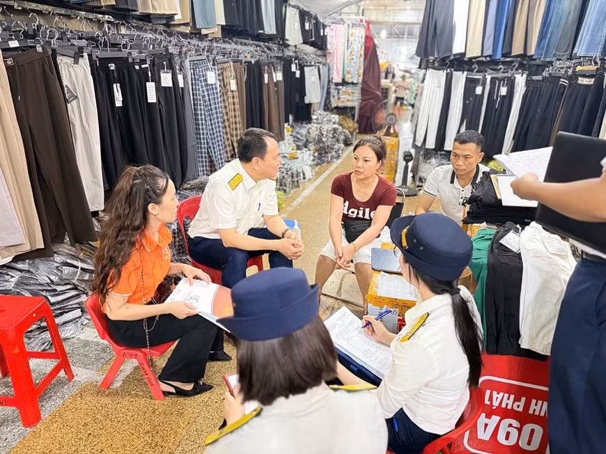 Cán bộ ngành thuế hướng dẫn hộ kinh doanh chuyển đổi mô hình từ thuế khoán sang kê khai. Ảnh: HUY HÙNG
