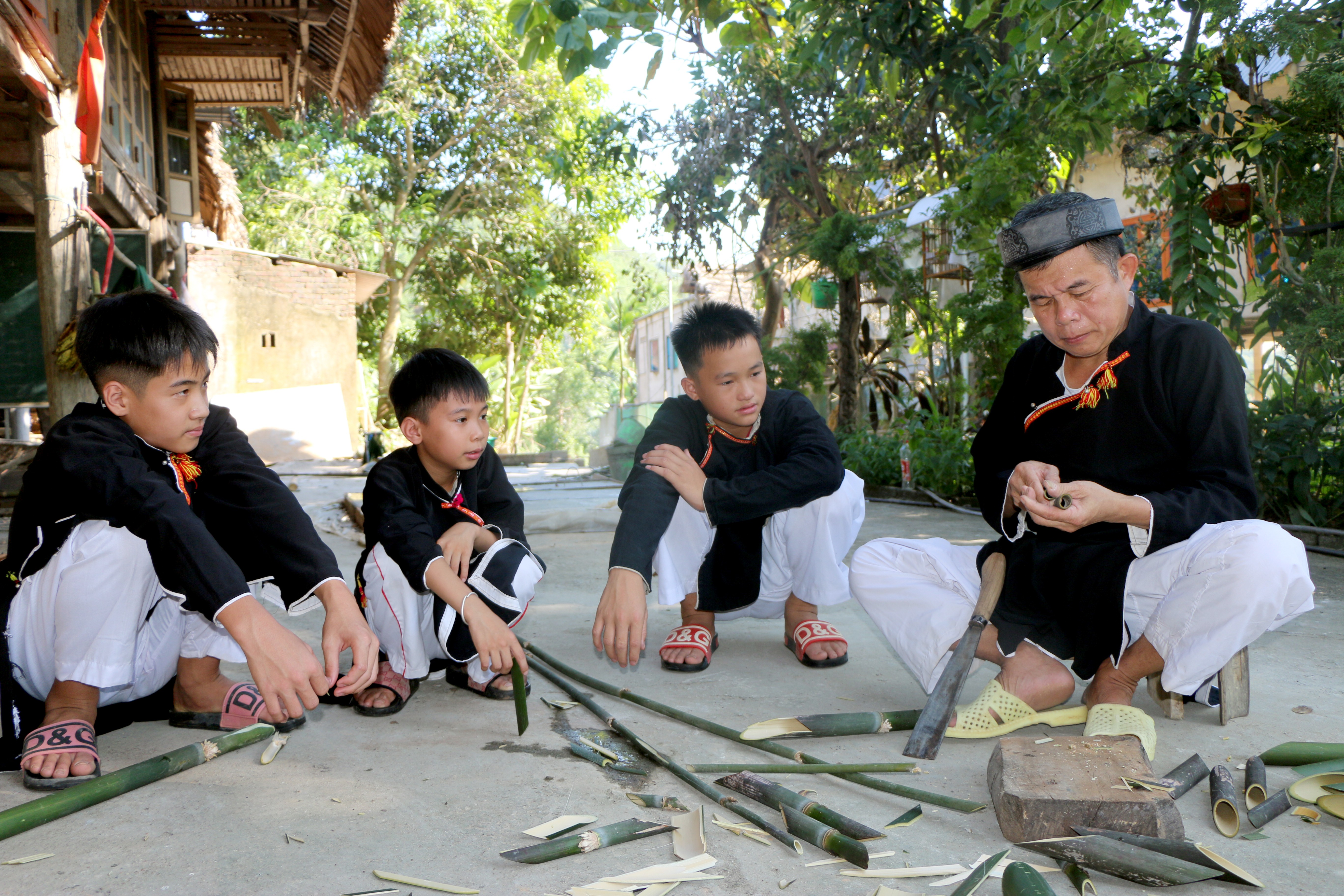 Nghệ nhân ưu tú Hoàng Hữu Định hướng dẫn các cháu nhỏ trong làng làm khèn nứa. img-9959.jpg