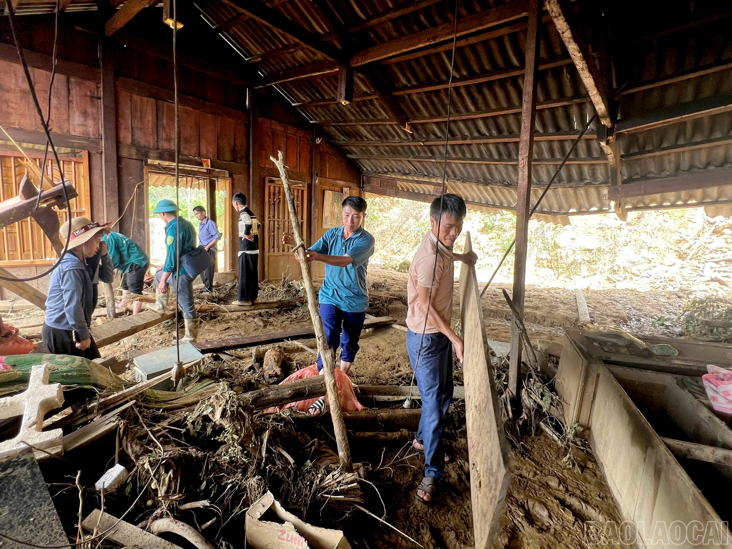 Anh Rình (áo xanh thứ 2 từ phải sang) cùng bà con trong thôn hỗ trợ, giúp đỡ dọn dẹp, dựng lại nhà cho các gia đình bị thiệt hại. baolaocai-br_z7076718881132-1821bc4256d3d2456c05b21b19090207.jpg