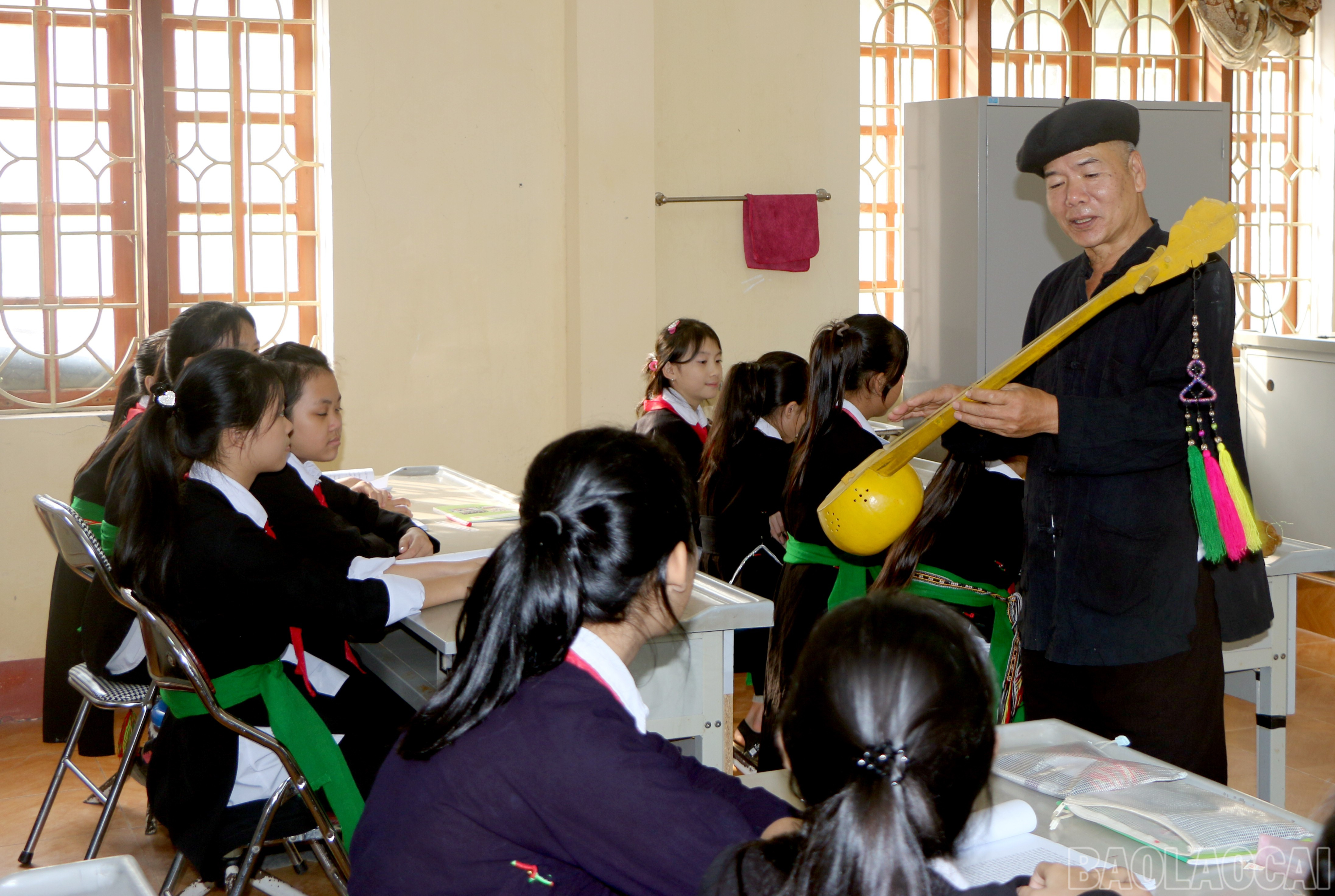 Học sinh dân tộc Tày lắng nghe nghệ nhân giới thiệu nhạc cụ và làn điệu truyền thống. Trong không gian ấy, âm nhạc dân gian không chỉ vang lên mà còn lan tỏa, sống động qua từng thế hệ. baolaocai-br_img-9293.jpg