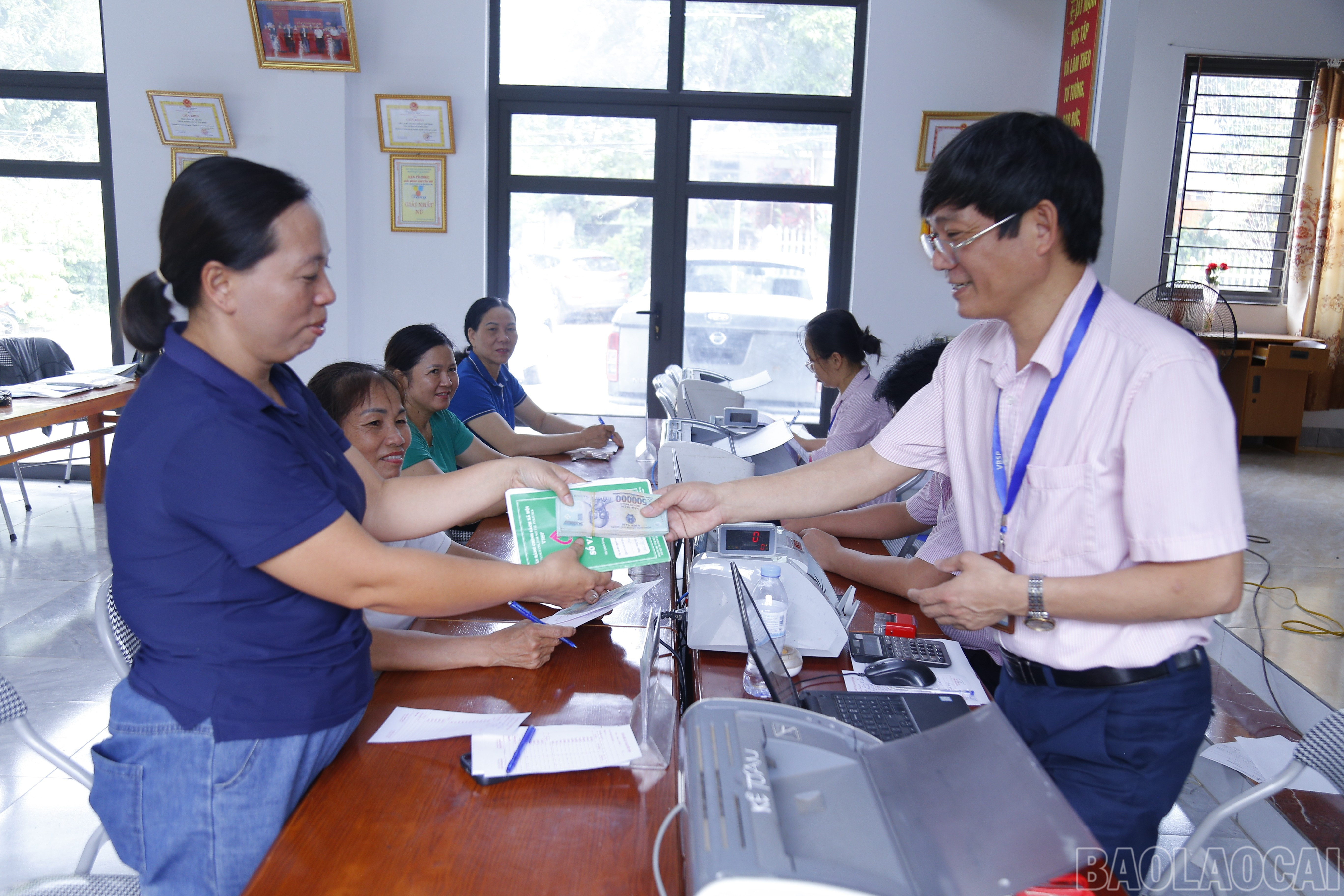 Cán bộ Phòng giao dịch Ngân hàng Chính sách xã hội Yên Bình giải ngân vốn cho các đối tượng chính sách tại thôn Hương Lý, xã Yên Bình. baolaocai-br_mg-7284.jpg