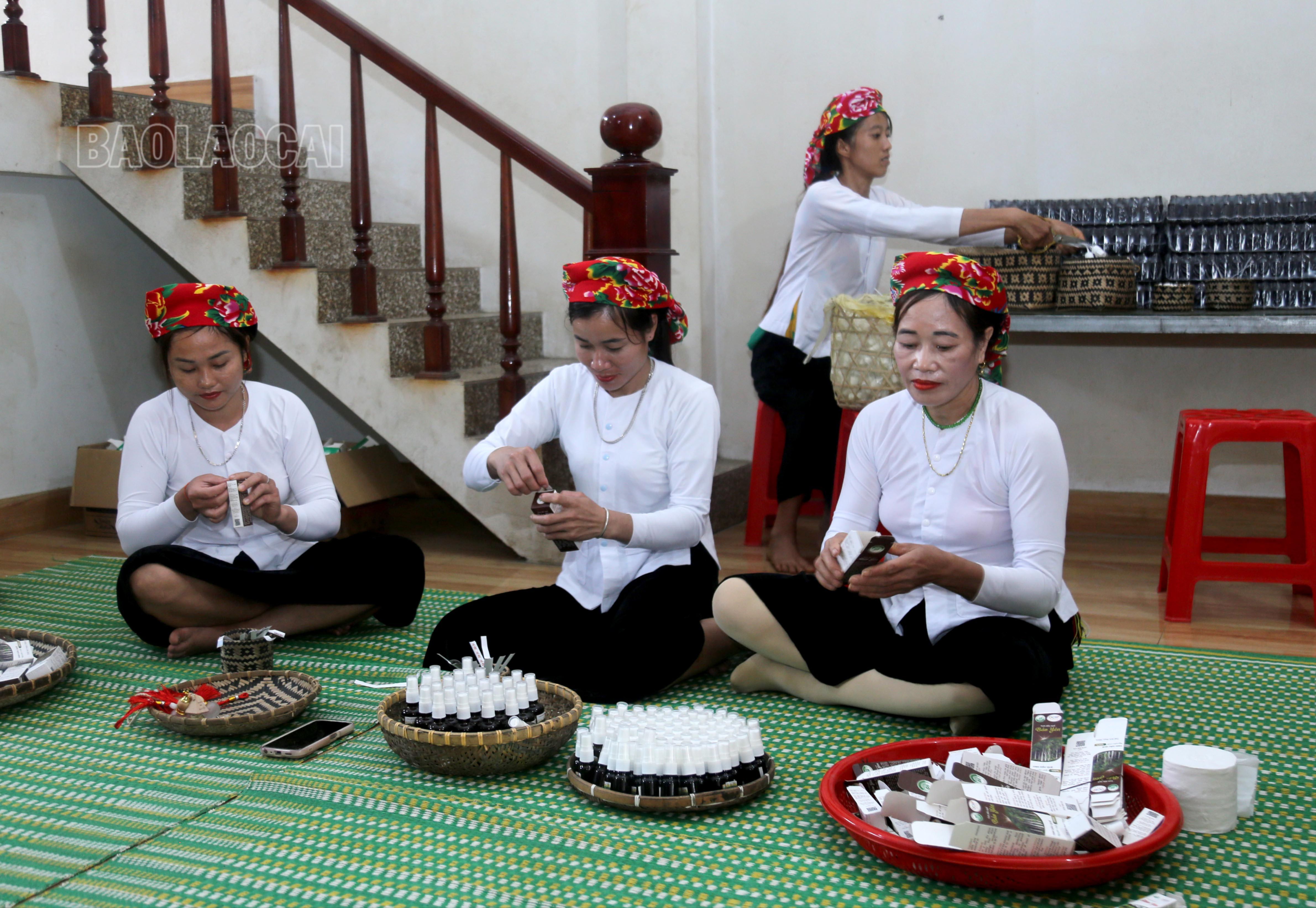 Phụ nữ bản Khuổi Phường tham gia phát triển ngành nghề mới. Trong ảnh: Đóng chai tinh dầu quế được chiết xuất tại địa phương. IMG_2953.JPG