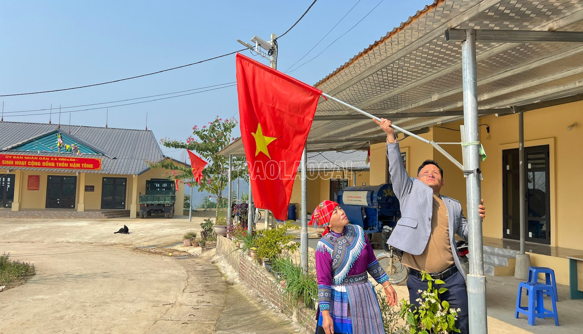 Anh Ma A Chểnh, thôn Nậm Tông cùng vợ cẩn thận treo lại lá cờ Tổ quốc trước hiên nhà.