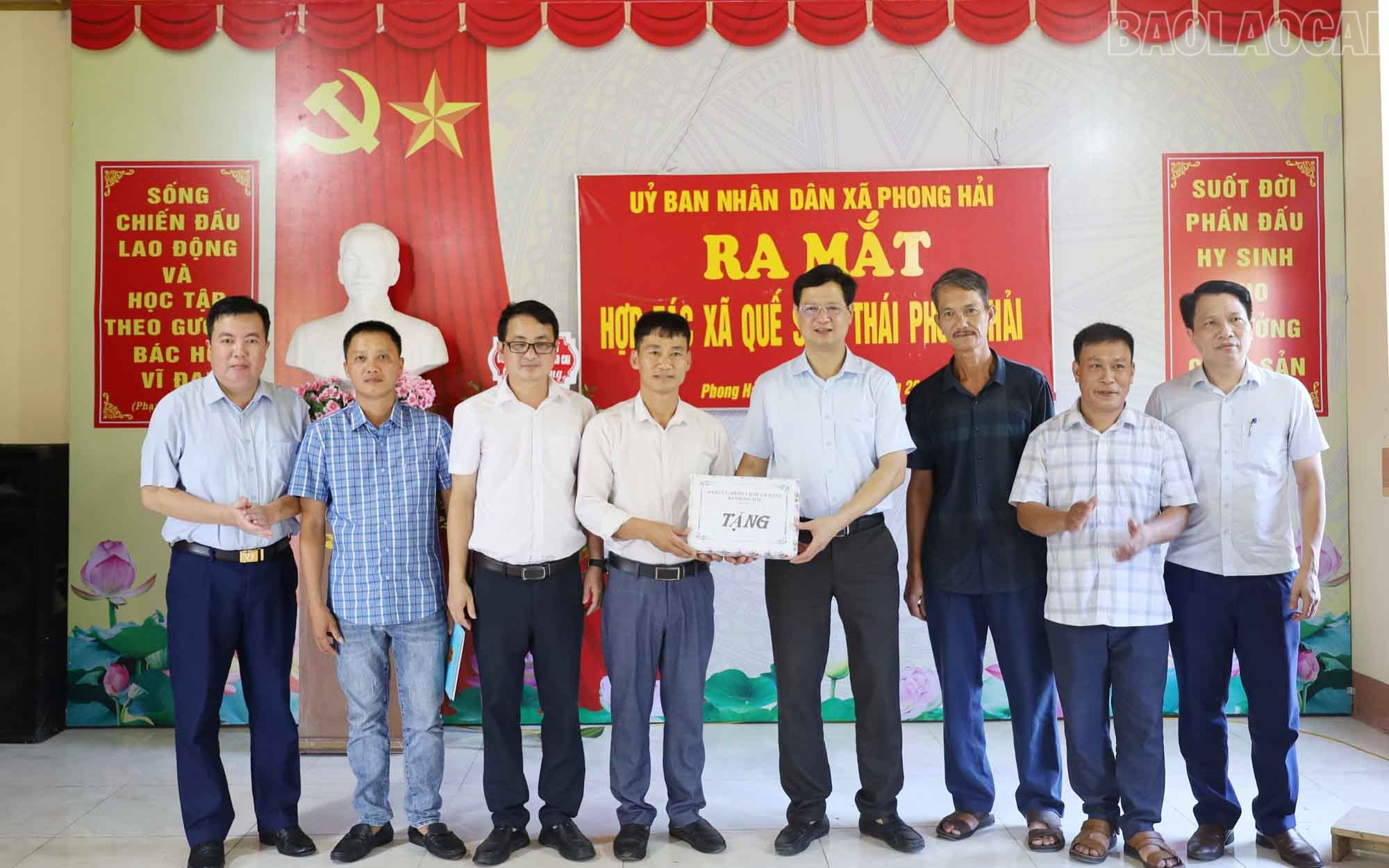 Đại diện UBND xã Phong Hải và doanh nghiệp tặng hoa chúc mừng Hợp tác xã Quế sinh thái Phong Hải. baolaocai-tr_2.jpg