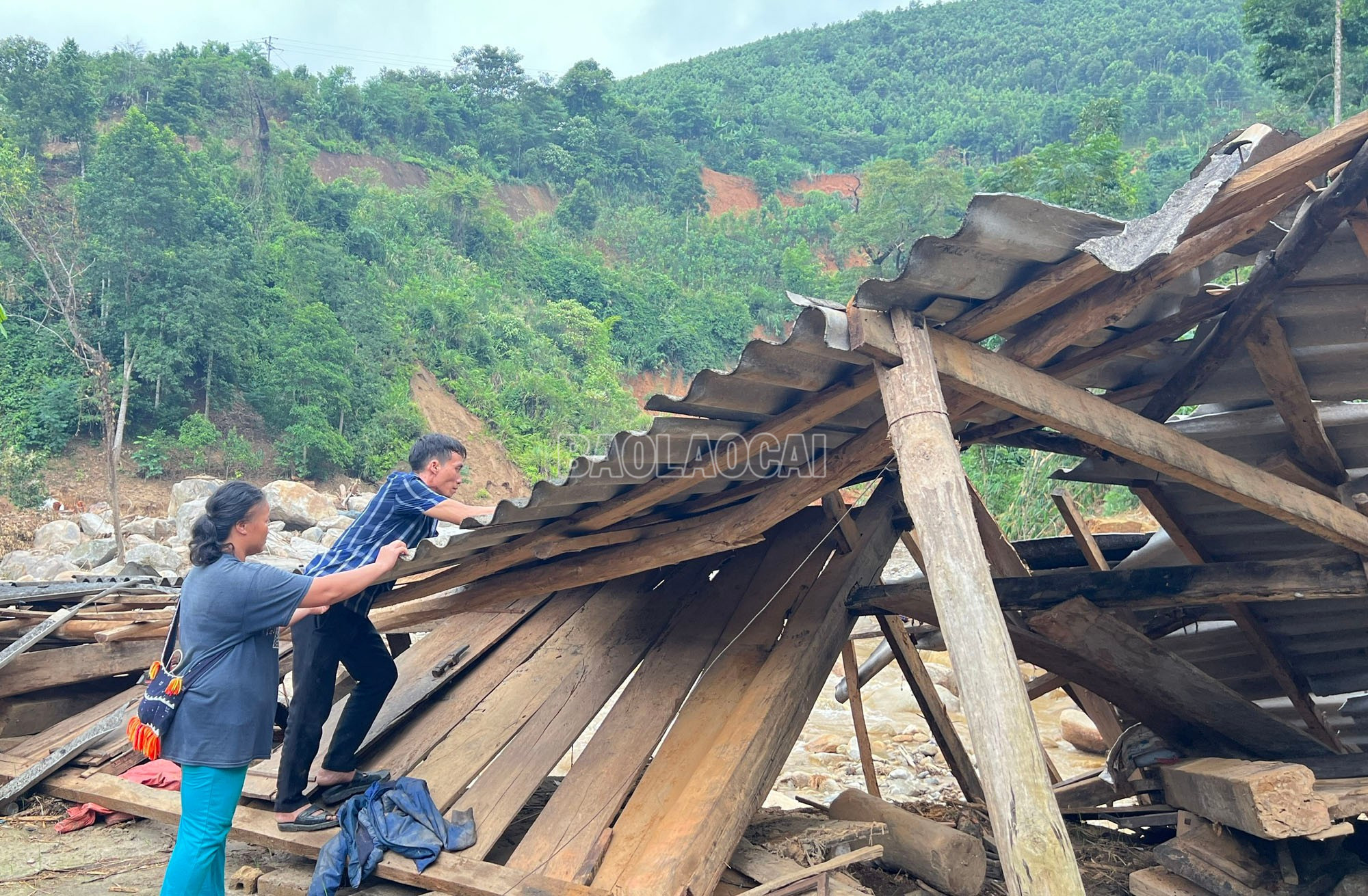 Vợ chồng anh Nguyên dọn đống đổ nát của ngôi nhà còn sót lại sau trận lũ. baolaocai-c_a.jpg
