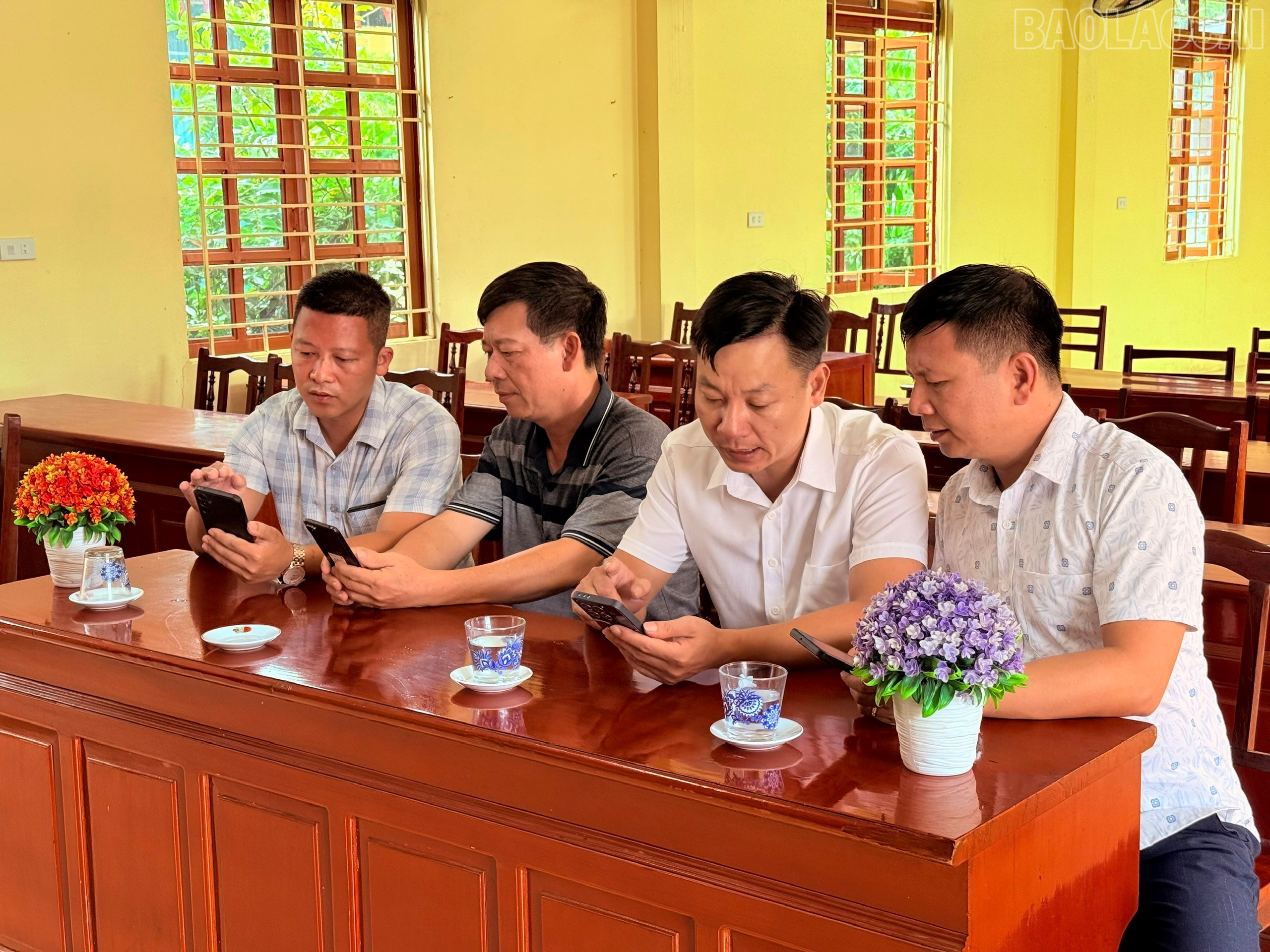 Đồng chí Phạm Quang Nhật (ngoài cùng bên phải) - Phó Giám đốc Trung tâm Truyền thông và Văn hoá Văn Yên trao đổi cùng Chi bộ thôn Hồng Hà về công tác tuyên truyền trên loa truyền thanh cơ sở. baolaocai-tr_ma.jpg