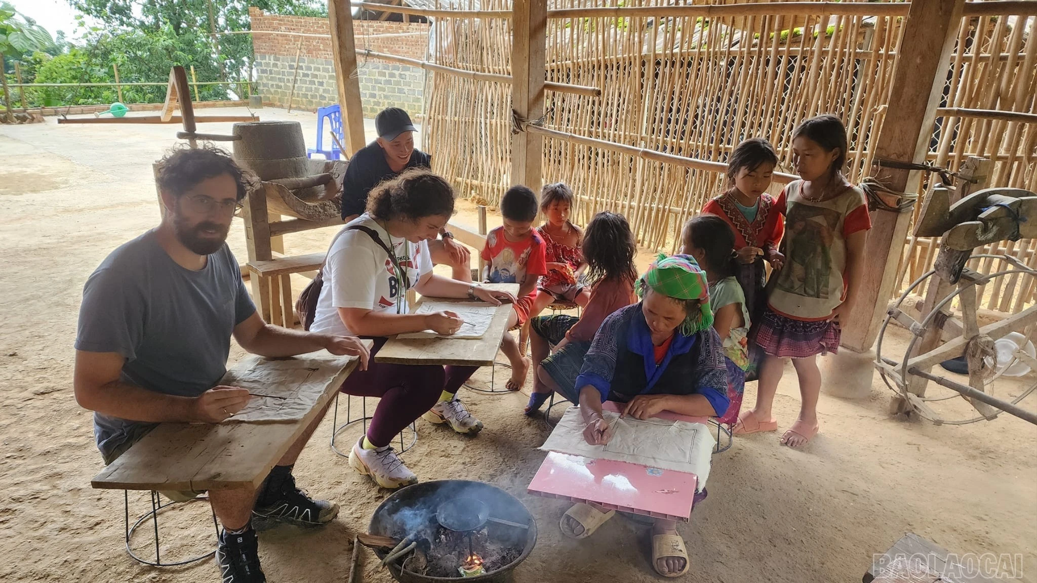 Du khách nước ngoài trải nghiệm hoạt động vẽ sáp ong của đồng bào dân tộc Mông ở Mù Cang Chải.