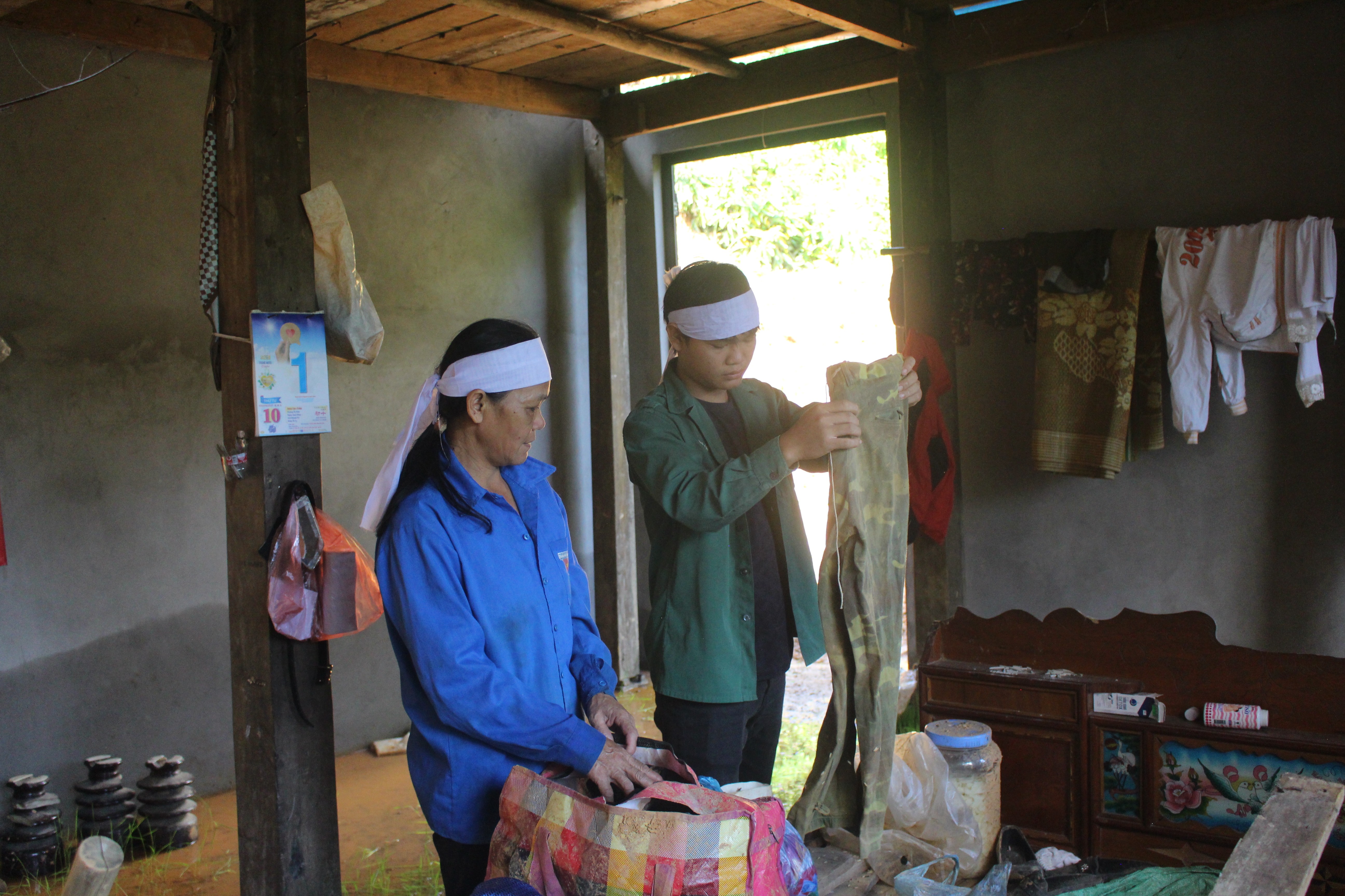 Bà Khang cùng con trai thu dọn di vật của người chồng đã mất do sạt lở đất. img-2083.jpg