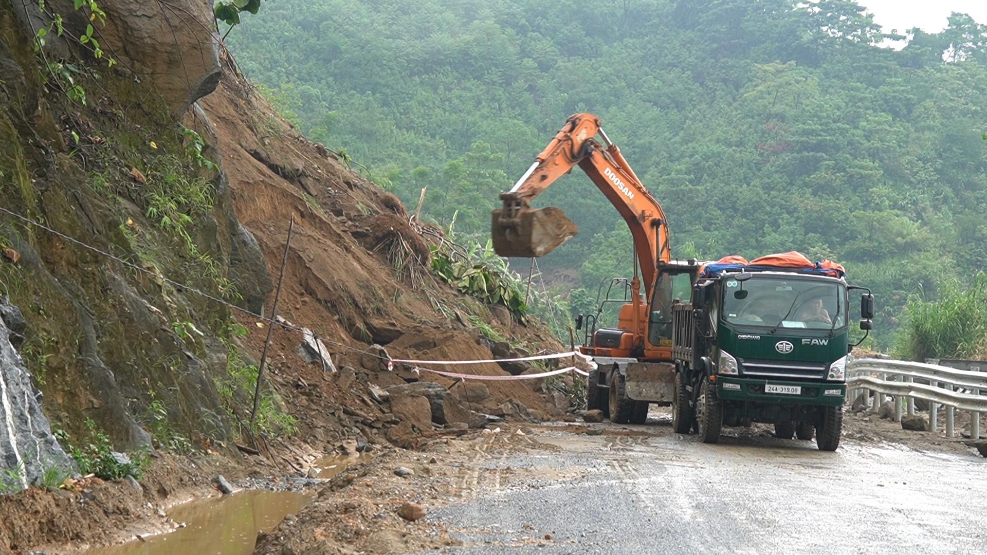 Máy xúc và xe tải được huy động xử lý đất đá tràn xuống mặt đường tại điểm sạt lở, đảm bảo giao thông bước 1 cho các phương tiện lưu thông. 3615230799af10f149be.jpg