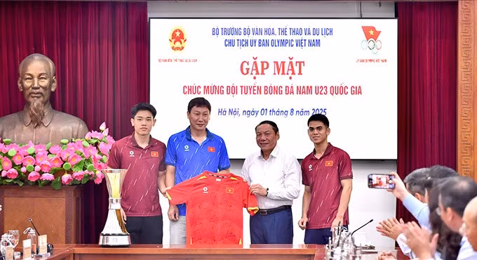 HLV Kim Sang Sik và các cầu thủ trao tặng Bộ trưởng Nguyễn Văn Hùng áo thi đấu có chữ ký của toàn đội.