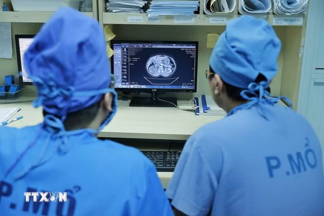 Các bác sỹ Bệnh viện Đại học Y Hà Nội xem hồ sơ bệnh án của bệnh nhân trước khi vào phẫu thuật.