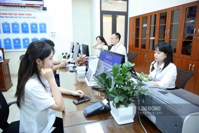 Bộ Nội vụ nêu các tiêu chí để địa phương chủ động bố trí, giao, điều chỉnh biên chế cấp xã. Trong ảnh, người dân phường Cầu Giấy (Hà Nội) giải quyết thủ tục hành chính. Ảnh: Phạm Đông