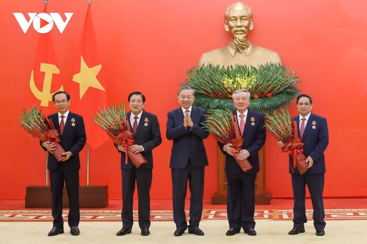 Tổng Bí thư Tô Lâm tặng hoa chúc mừng các đồng chí được nhận Huân chương Quân công hạng nhất.