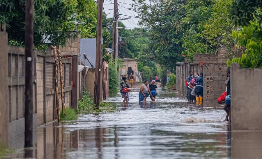 Người dân lội qua vùng nước lũ do mưa lớn tại thành phố Matola, tỉnh Maputo, Mozambique.