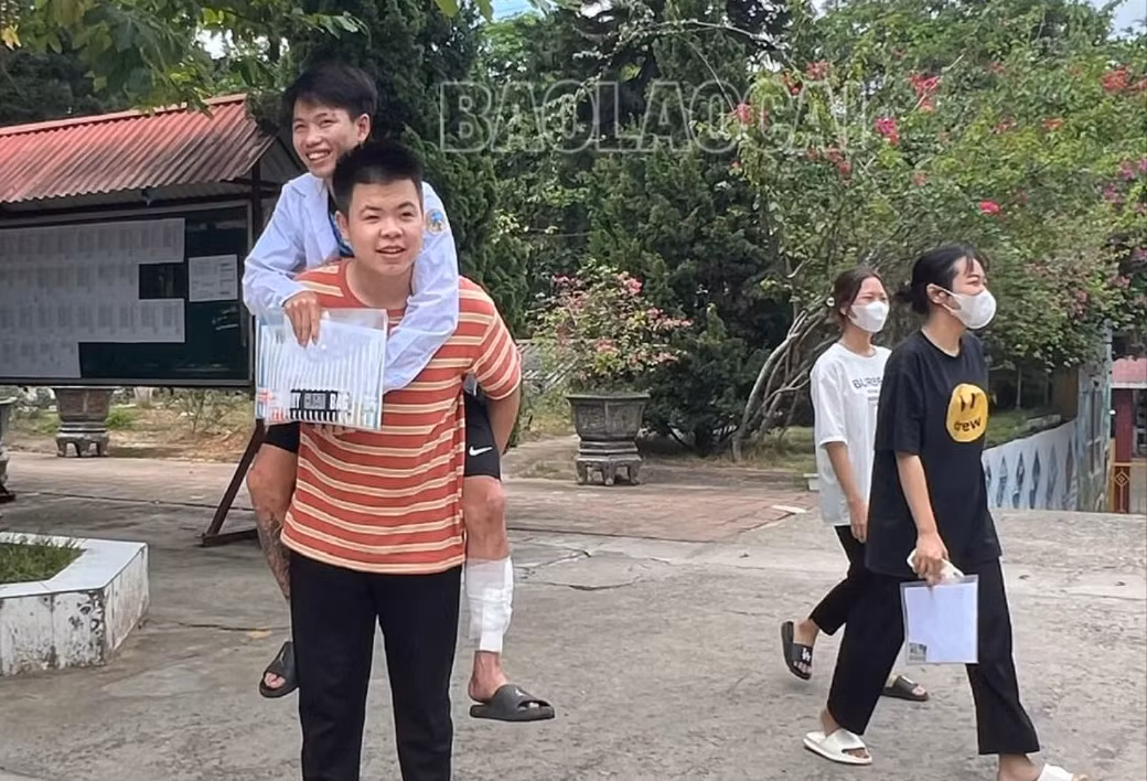 Tô Việt Anh cõng bạn đến phòng thi..jpg