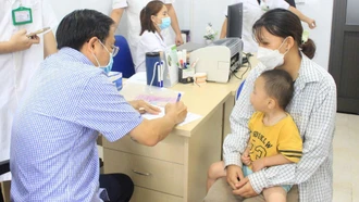 Chuyên gia y tế tuyến trung ương khám sàng lọc cho trẻ em khuyết tật.