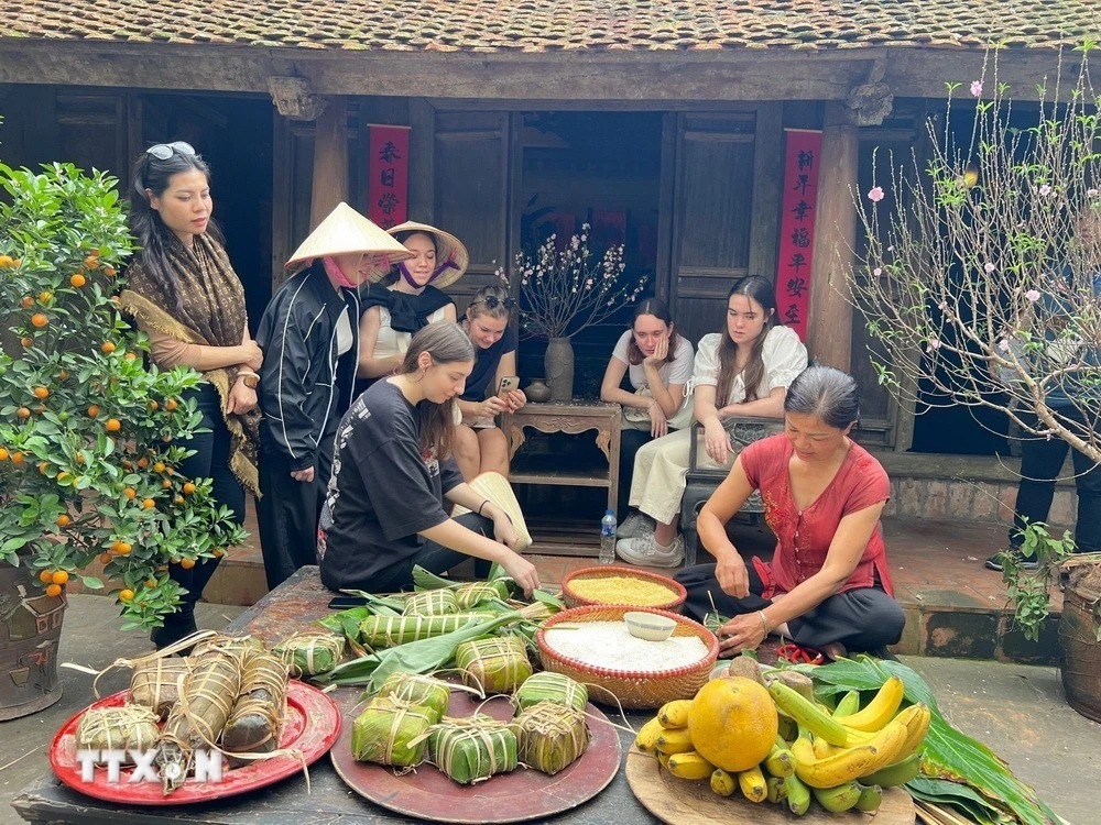 Khách quốc tế trải nghiệm gói bánh chưng tại Làng cổ Đường Lâm.