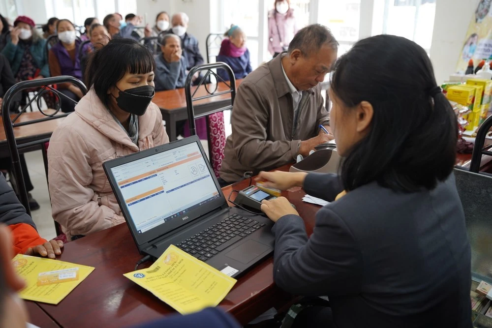 Nhân viên VNPost chi trả lương hưu cho người cao tuổi.