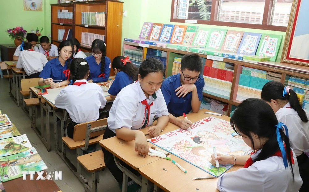 Các em học sinh người Việt và người Lào tại Trường song ngữ Lào - Việt Nam Nguyễn Du tham gia hoạt động ngoại khóa vẽ tranh Bác Hồ.