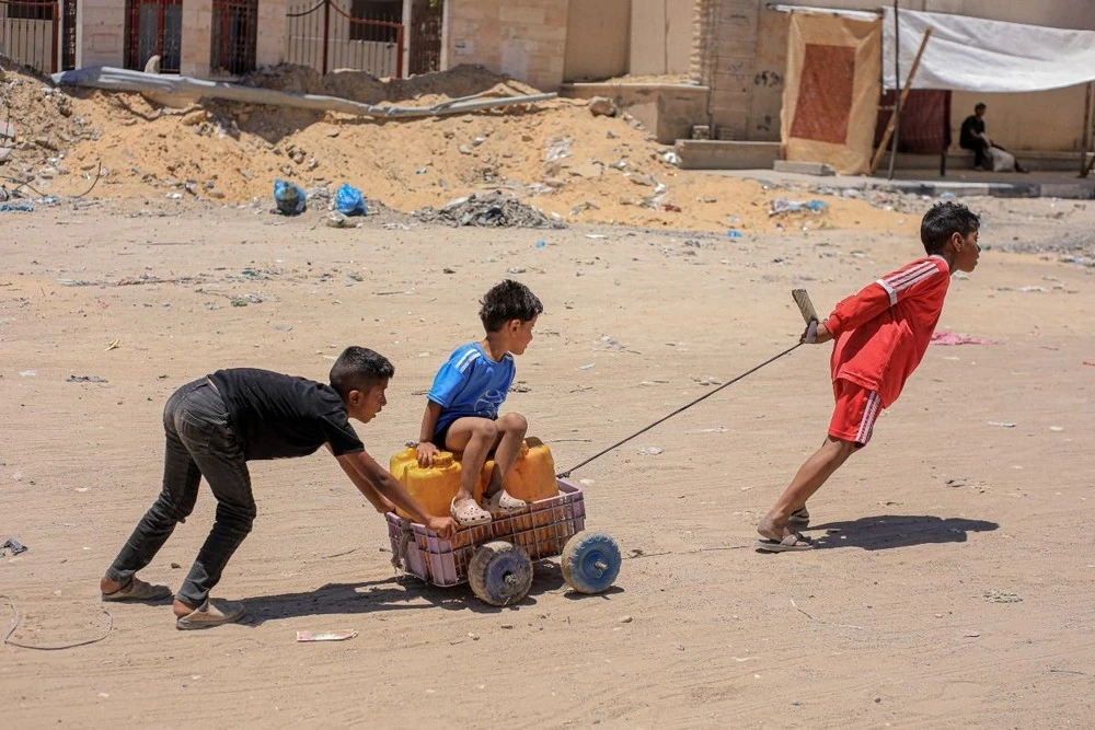 Các em nhỏ vận chuyển nước tại Khan Younis, Dải Gaza, ngày 31/5/2024.