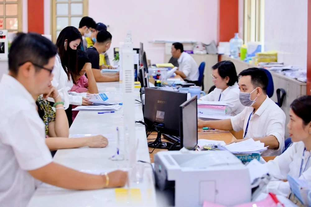Cán bộ ở TP.HCM hỗ trợ giải quyết thủ tục hành chính cho người dân.
