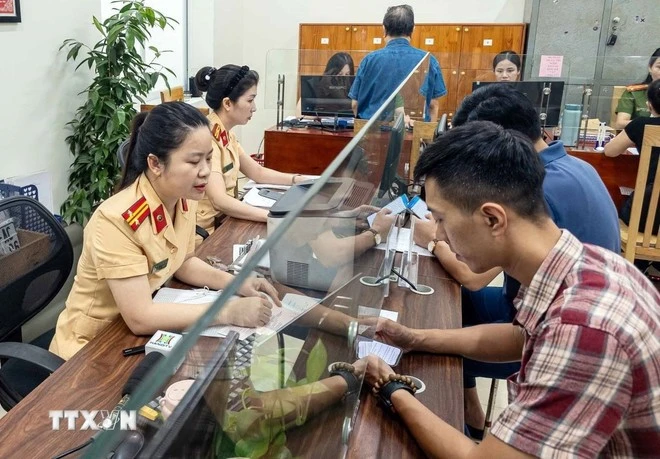 Người dân đến làm thủ tục đăng ký xe tại Công an phường Giảng Võ, thành phố Hà Nội.