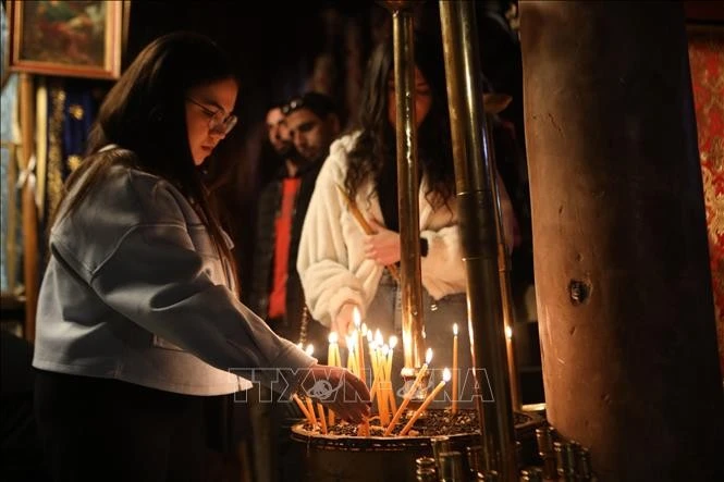Người dân thắp nến tại Nhà thờ Giáng sinh ở Bethlehem, Bờ Tây, ngày 22/12/2024.